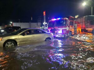 Un Bombero Con Sus Pies Empuja Un Vehículo Para Sacar De La Laguna Con La Máquina De Bomberos